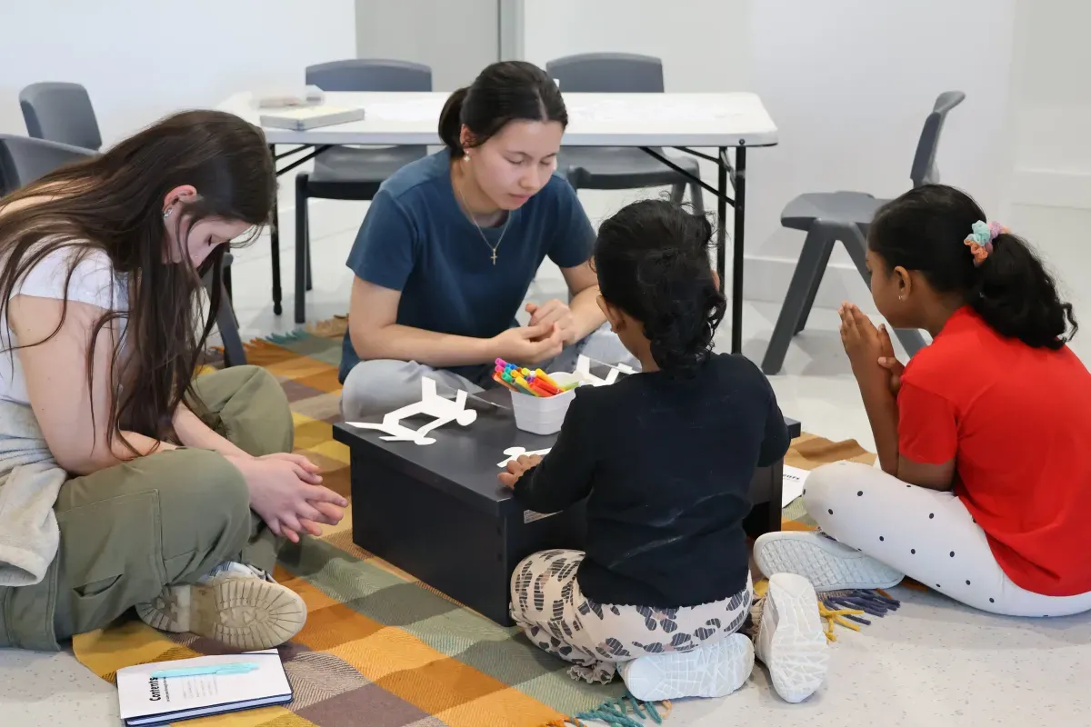 Young leaders doing a craft activity with children at PAC Kids