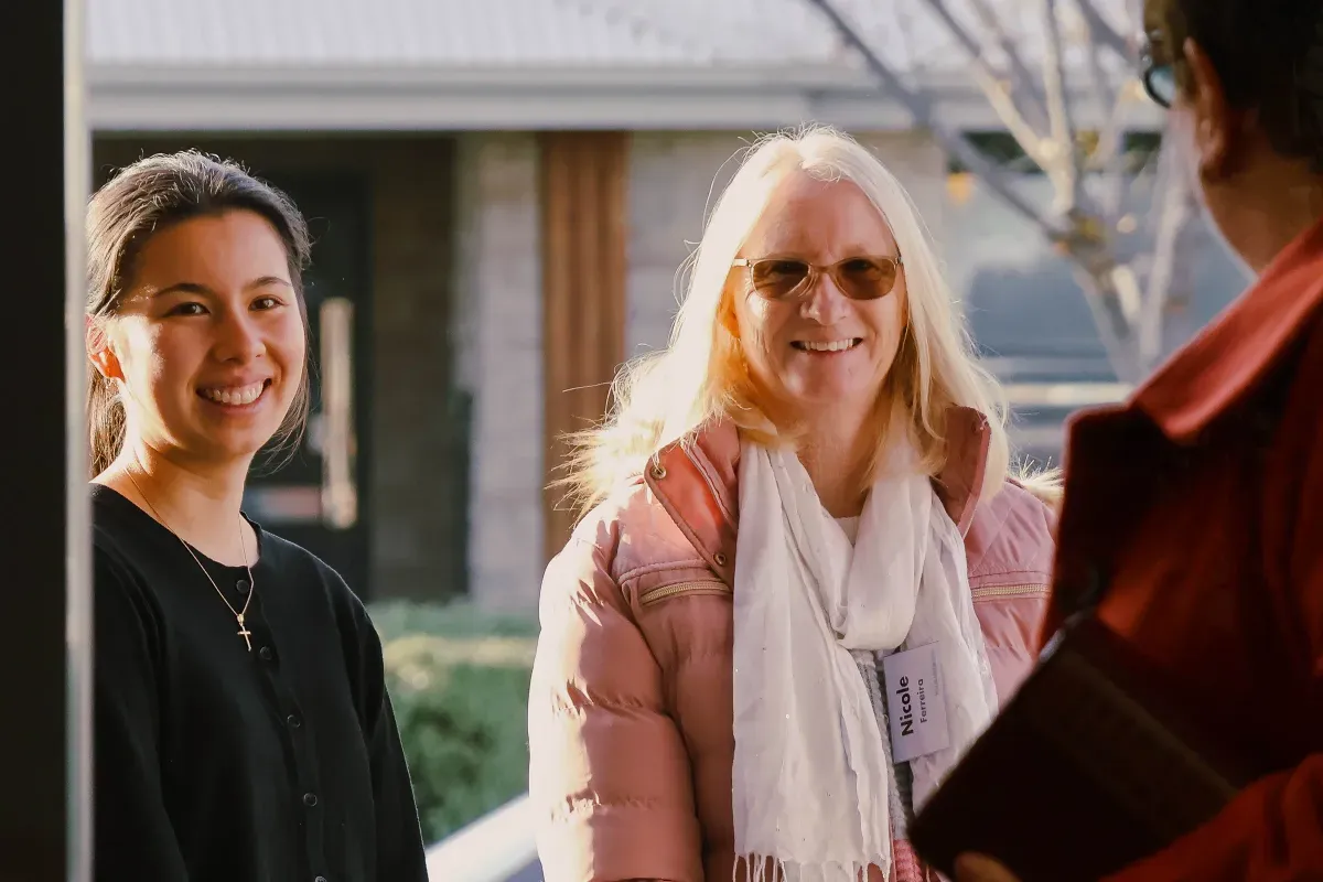 Two women smiling and chatting after church