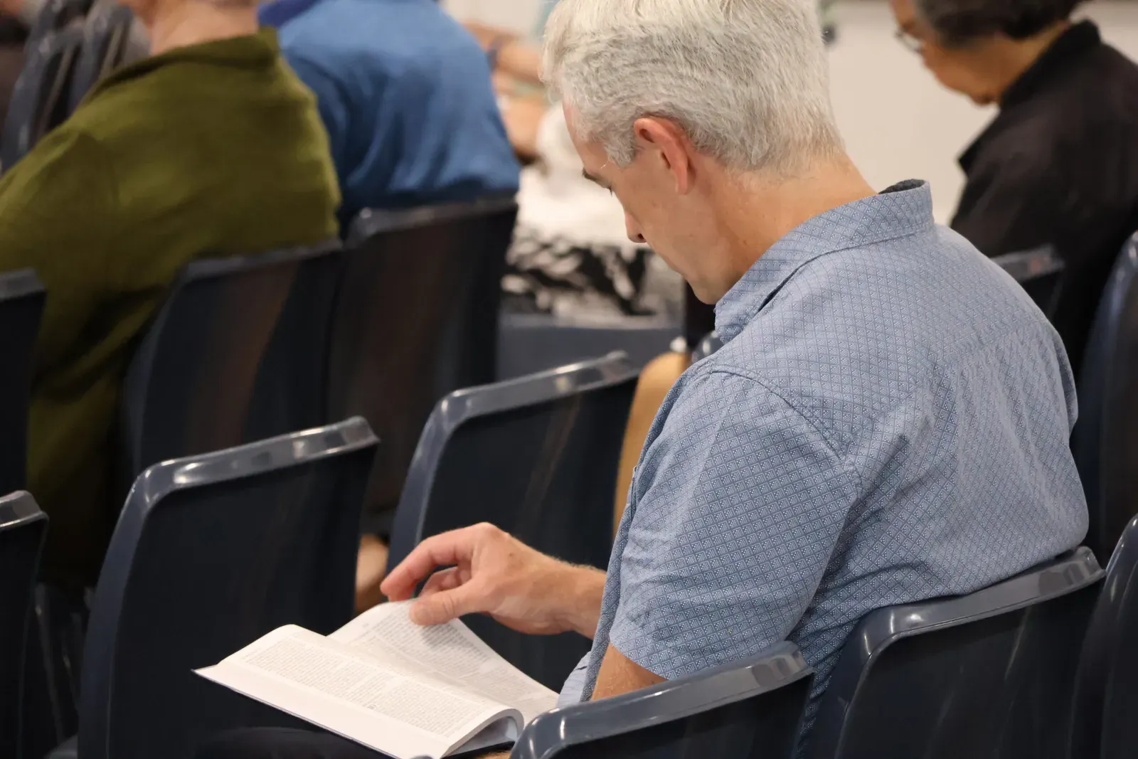 A church member following along in his Bible during the sermon